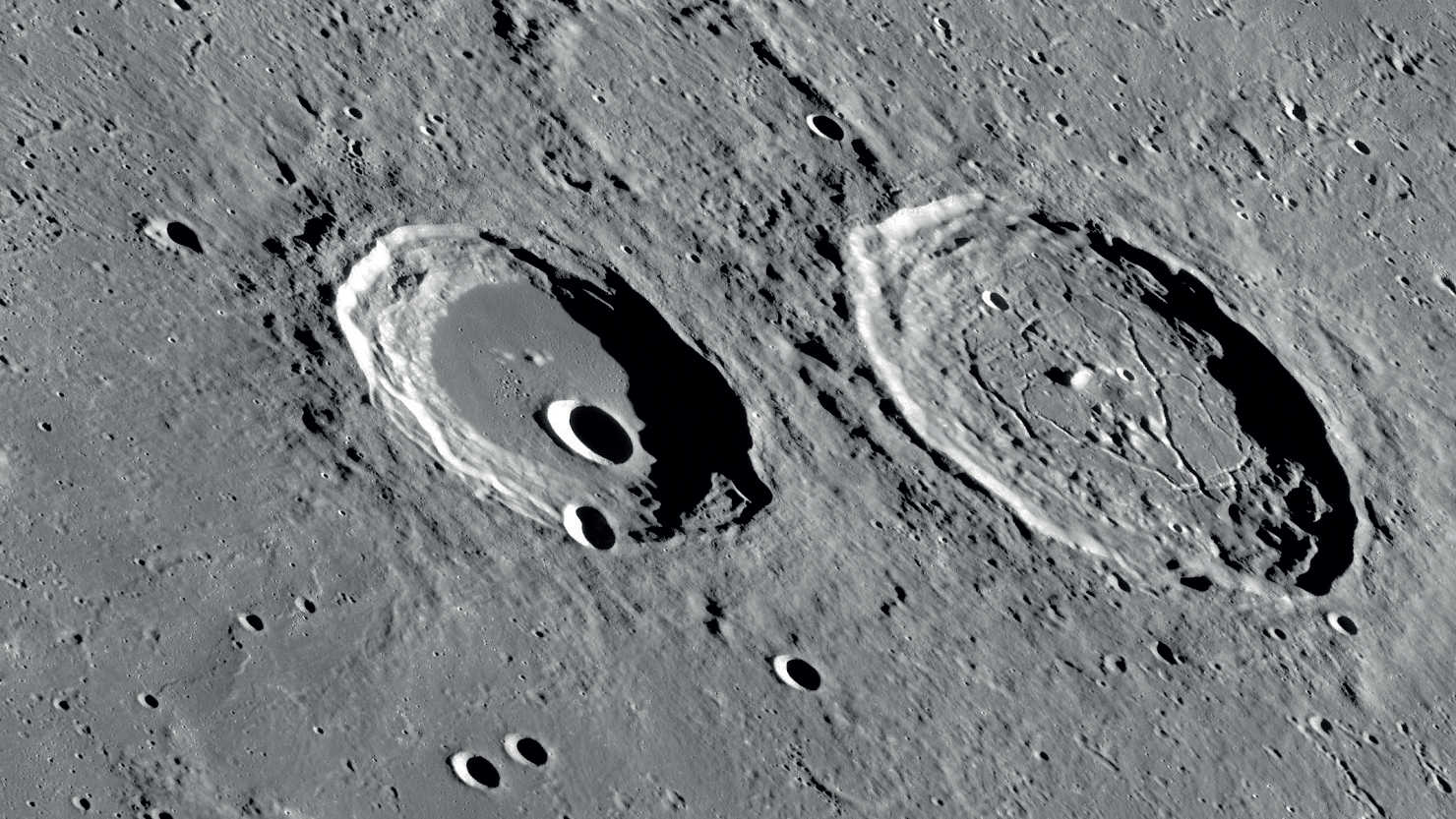 Cele două cratere, Atlas și Hercules, au un aspect foarte diferit. NASA/GSFC/Arizona State University